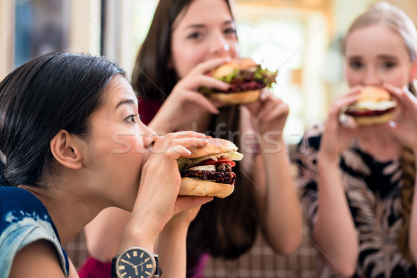 Portrait trois jeunes femmes manger regarder [[stock_photo]] © Kzenon