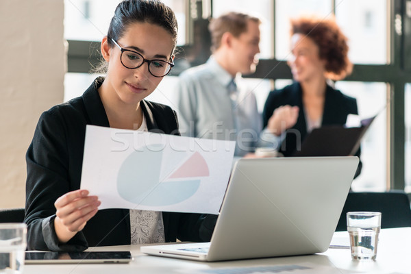 Hard-working young woman analyzing business information Stock photo © Kzenon
