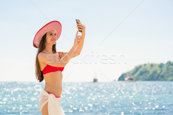 Attractive young woman making a selfie on the beach during vacat Stock photo © Kzenon