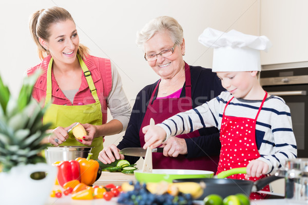 Granny, mum and son talking while cooking in kitchen Stock photo © Kzenon