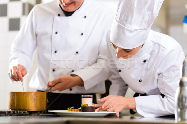 Stock photo: Chef team in restaurant kitchen with dessert