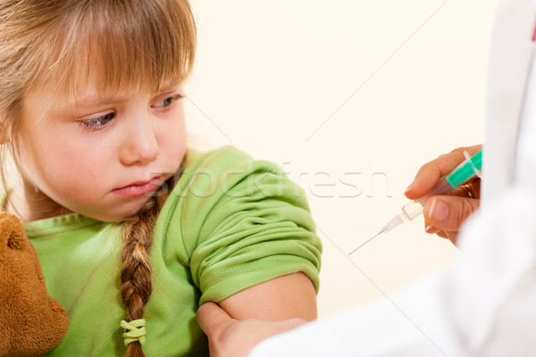 Pediatrician doctor applying syringe to child  Stock photo © Kzenon