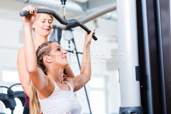 Woman doing back training with trainer in gym Stock photo © Kzenon