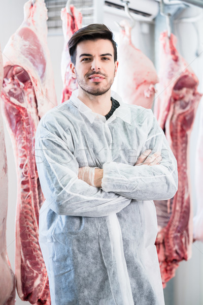Worker in butchery standing in front of carcasses Stock photo © Kzenon