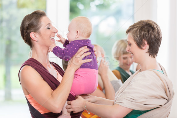 Young women learn how to use baby carriers for carrying children Stock photo © Kzenon