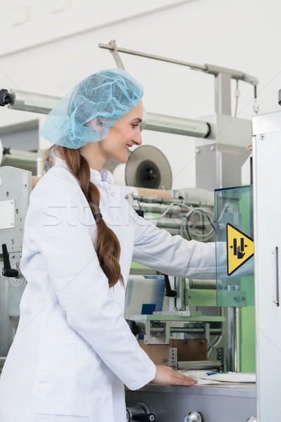 Woman manufacturing engineer adjusting the settings of an industrial machine Stock photo © Kzenon