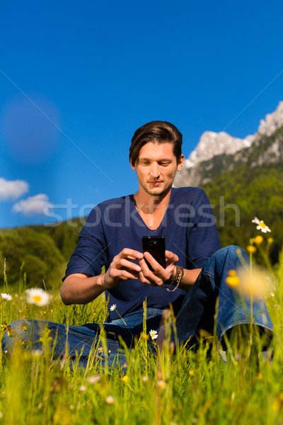 man with phone  sitting in the mountains  Stock photo © Kzenon