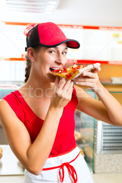 Woman eating a slice of pizza Stock photo © Kzenon