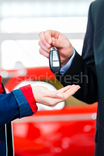 Woman with key to new auto in car dealership Stock photo © Kzenon