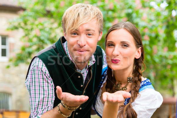 Couple in Bavarian clothes blows a kiss Stock photo © Kzenon