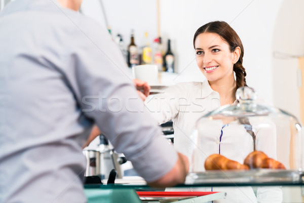 Beautiful waitress serving male customer with a cup of coffee fo Stock photo © Kzenon