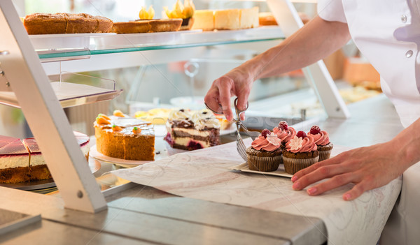 Baker sales woman putting pies and cakes on display Stock photo © Kzenon