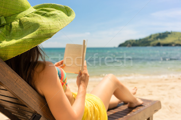 Young beautiful woman reading a book at the beach in a sunny day Stock photo © Kzenon