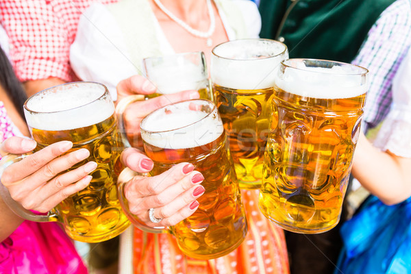 Clinking glasses with beer in Bavarian beer garden Stock photo © Kzenon