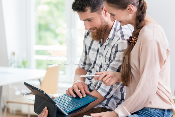 Stock photo: Cheerful young man collaborating with his female co-worker