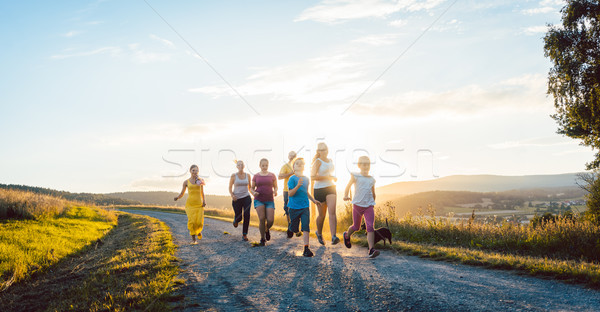 Playful family running and playing on a path in summer landscape Stock photo © Kzenon