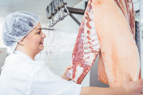 Butcher woman cutting meat for further use Stock photo © Kzenon