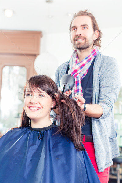 Hairdresser blow dry woman hair in shop Stock photo © Kzenon