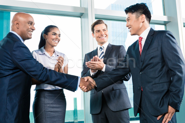 Business handshake in lofty office with city view Stock photo © Kzenon