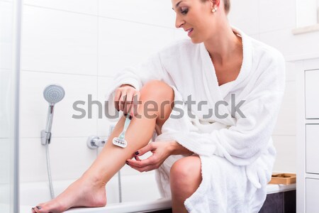 Stock photo: Woman applying peeling at her legs 