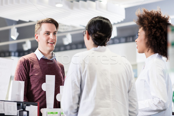 Happy customer talking with two helpful pharmacists in a contemp Stock photo © Kzenon