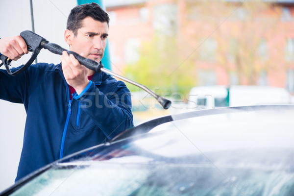 Dedicated worker washing car with high-pressure hose Stock photo © Kzenon