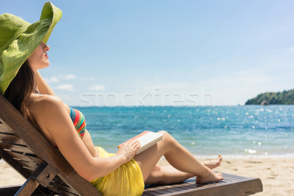 Young beautiful woman reading a book at the beach in a sunny day Stock photo © Kzenon