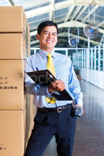 Young Indonesian worker in warehouse with Scanner Stock photo © Kzenon