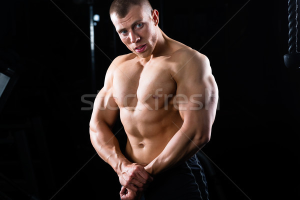 Culturist prezinta sală de gimnastică puternic om gantere Imagine de stoc © Kzenon