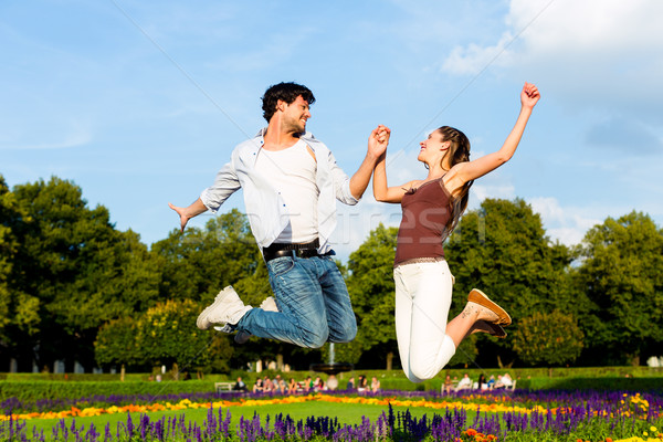 Tourist couple in city park jumping in sun Stock photo © Kzenon