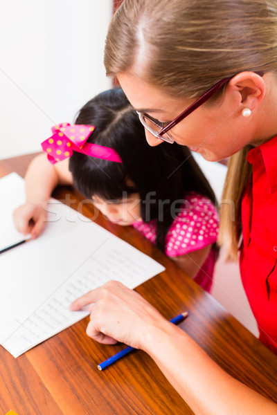 English private teacher working with Asian girl  Stock photo © Kzenon