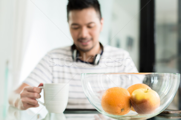 Indonesian man drinking coffee at breakfast Stock photo © Kzenon