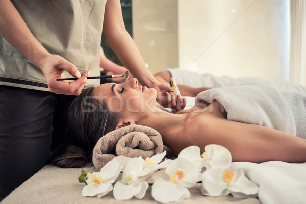 Relaxed woman lying down on massage bed during facial treatment Stock photo © Kzenon