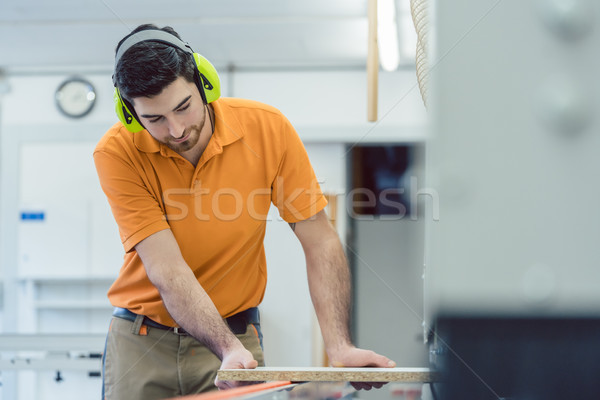 Carpenter working in furniture factory on machine Stock photo © Kzenon