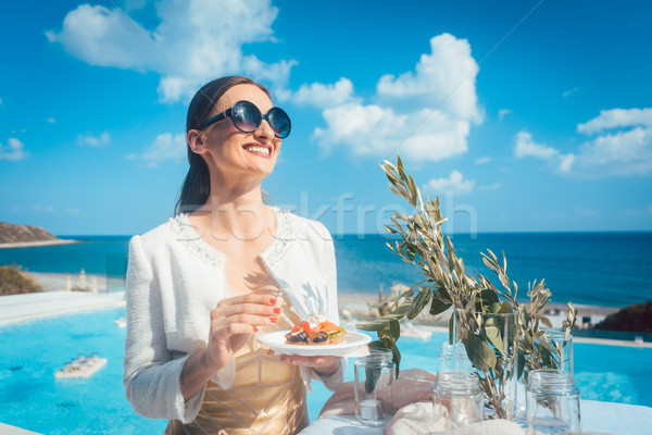 Woman enjoying some good food on beach house party Stock photo © Kzenon