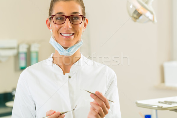 Dentist in her surgery hold mirror and scraper Stock photo © Kzenon