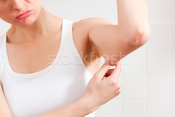 Woman is checking her triceps Stock photo © Kzenon