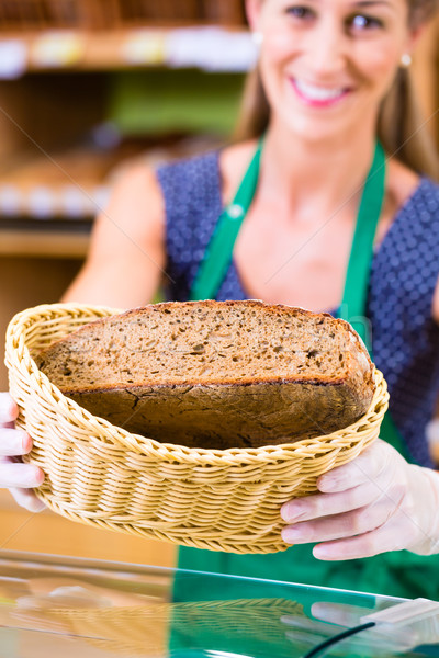 Bakery saleswoman offering bread Stock photo © Kzenon