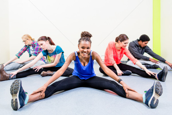 Young people stretching legs in gymnastics gym Stock photo © Kzenon
