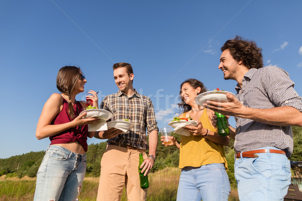 Friends at BBQ party in nature drinking beer and eating burgers Stock photo © Kzenon