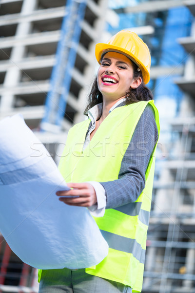 Female civil engineer studying drafts visiting construction site Stock photo © Kzenon