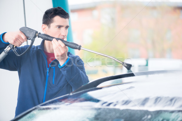 Dedicated worker washing car with high-pressure hose Stock photo © Kzenon