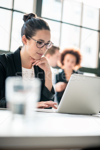 Two young malicious employees gossiping about their colleague Stock photo © Kzenon
