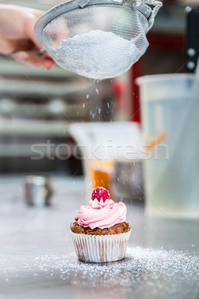 Stock photo: Woman in confectionary icing cupcakes with sugar