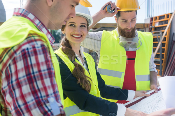 Confident female architect sharing ideas about the plan of a building Stock photo © Kzenon