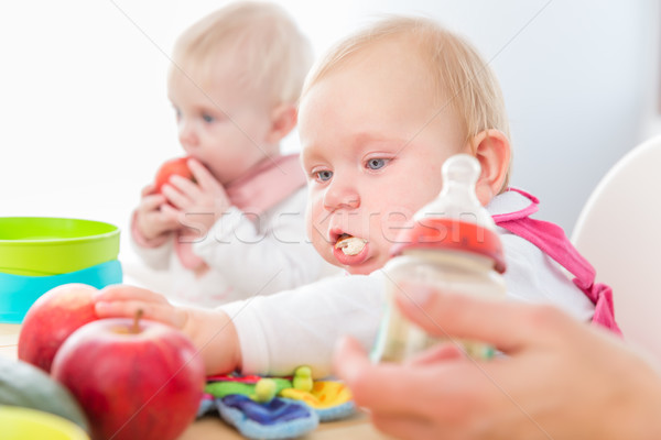 Cute baby girl eating healthy solid food in a modern daycare center Stock photo © Kzenon