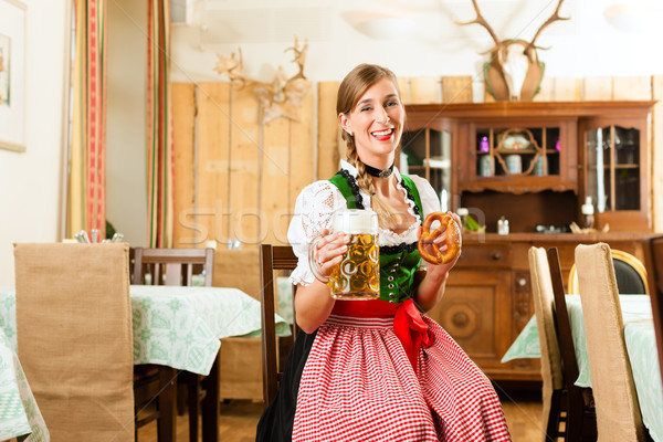 Young woman in traditional Bavarian Tracht in restaurant or pub Stock photo © Kzenon