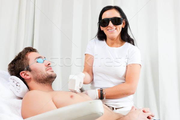 Man in cosmetic salon receiving waxing Stock photo © Kzenon