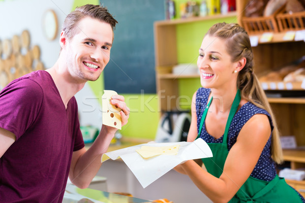 Saleswoman at counter offering cheese Stock photo © Kzenon