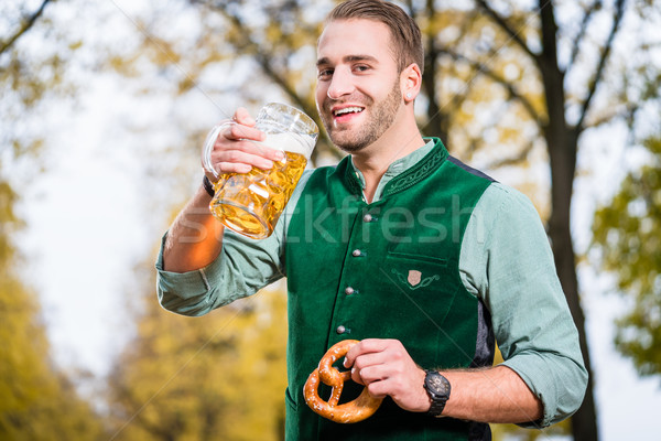 Man in traditional bavarian Tracht drinking beer out of huge mug Stock photo © Kzenon